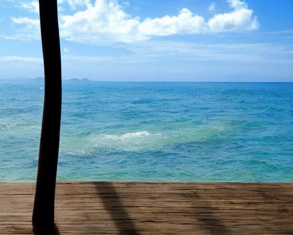 Serene seaside scene with wooden deck, blue skies, and turquoise waters