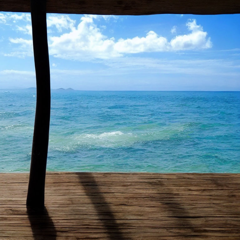 Serene seaside scene with wooden deck, blue skies, and turquoise waters