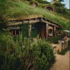 Tranquil painting of pathway to dark tunnel in lush green setting