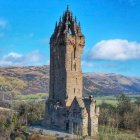 Tall stone tower with blue roof in autumnal forest under starry sky