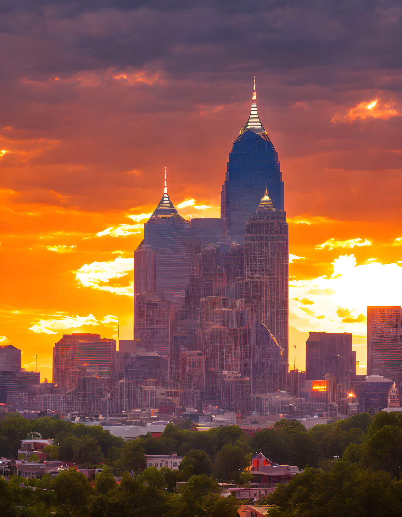 City skyline with silhouetted skyscrapers against vibrant sunset sky