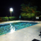 Tranquil outdoor pool at night with sparkling water and streetlamp glow