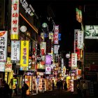 Futuristic cyberpunk cityscape at night with neon signs, train tracks, and silhouettes