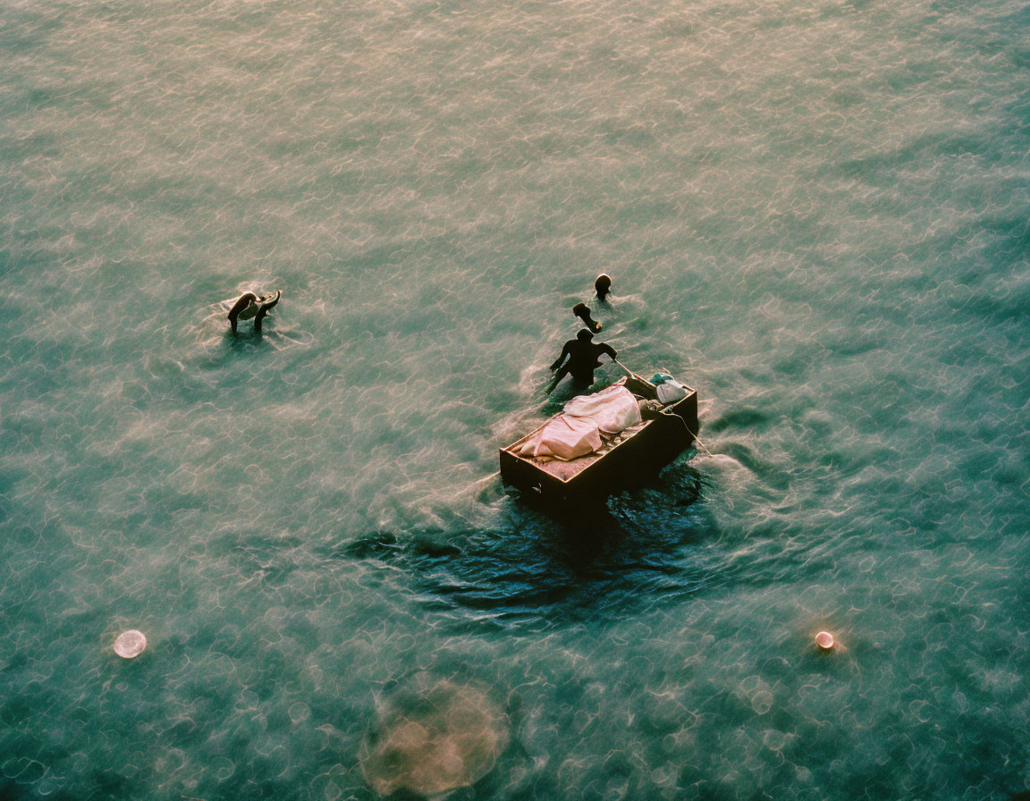 Three People in Small Boat with Jellyfish on Water