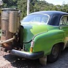 Vintage Green Steampunk-Designed Car on Cobblestone Path