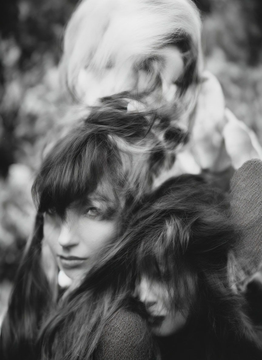 Monochrome photograph: Two individuals with intertwined hair symbolizing unity.