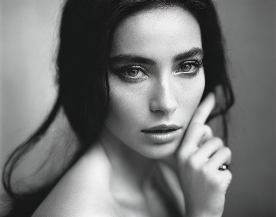 Monochrome close-up portrait of woman with intense eyes and thoughtful look