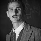 Monochrome portrait of man in military uniform with medals, cap, and mustache