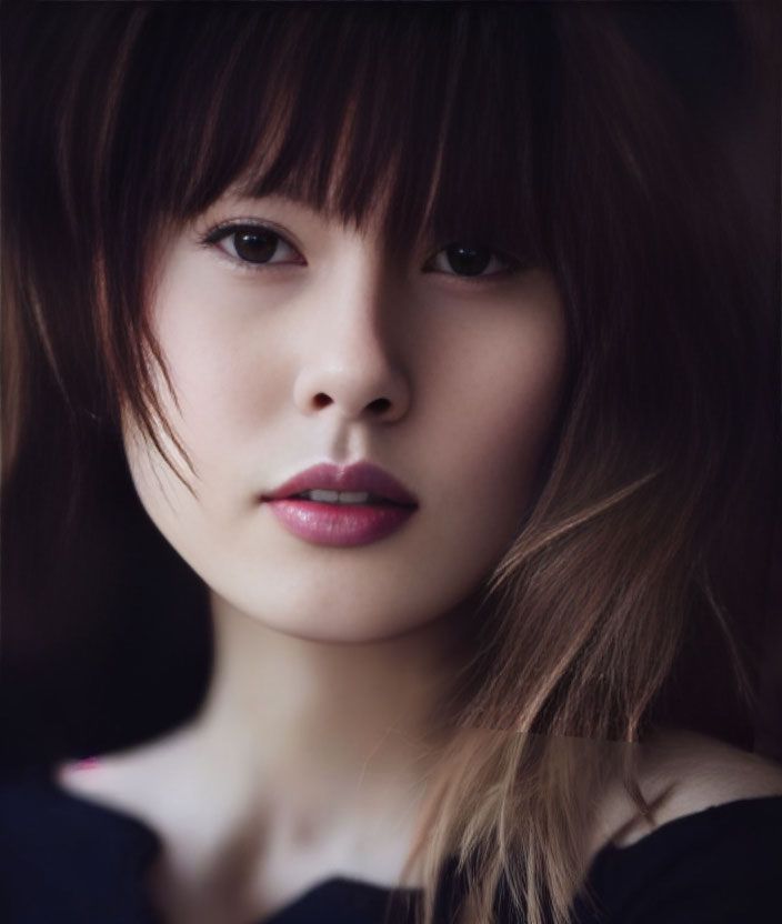 Dark-haired woman with bangs and pink lipstick in close-up portrait, featuring subtle gaze and tousled