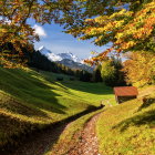 Vibrant autumn landscape with lake, boats, and snowy mountain