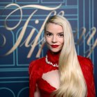 Person in Red Top with Striking Red Lips Poses Thoughtfully by Chessboard