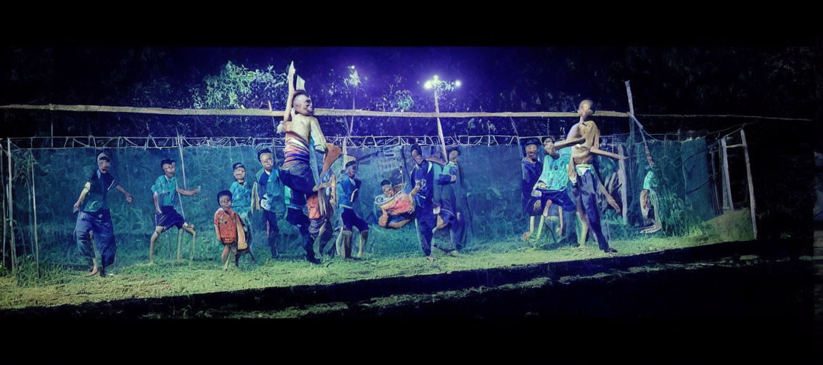 Nighttime tug-of-war under bright lights in grassy outdoor area