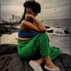 Woman sitting on rocky outcrop under stormy sky with dragon-like creature