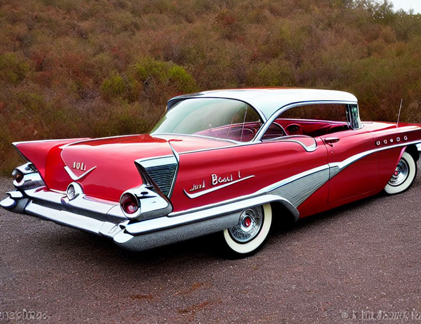 Vintage Red and White Two-Toned Car with Tailfins and White-Wall Tires on Asphalt