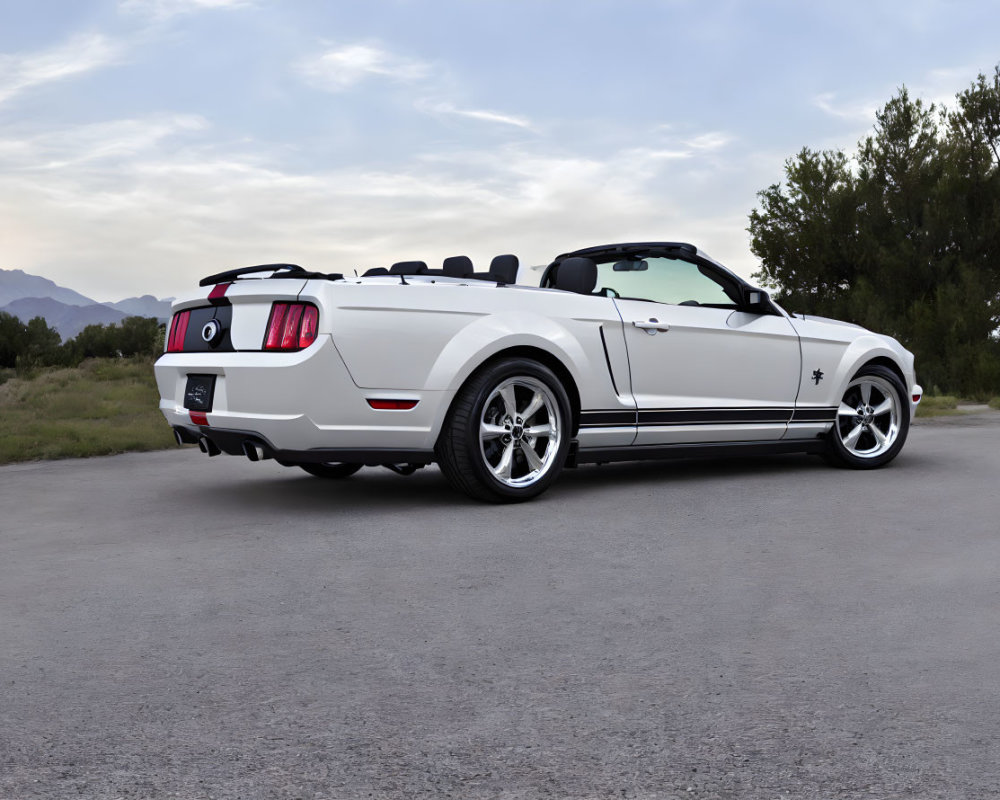 White Ford Mustang Convertible with Racing Stripes on Asphalt Road with Mountains and Trees