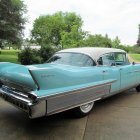 Classic Turquoise and White Car with Tailfins in Desert Sunset Scene