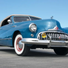 Vintage teal car with front grille parked on concrete surface