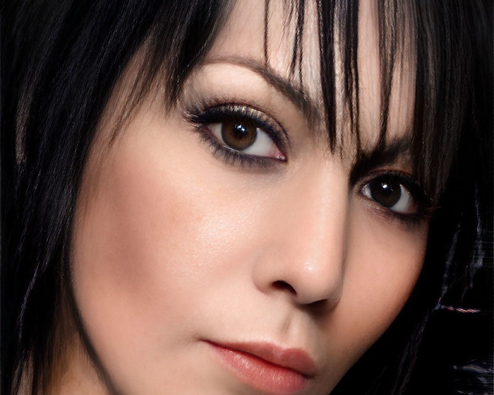 Portrait of woman with dark hair and striking eye makeup.