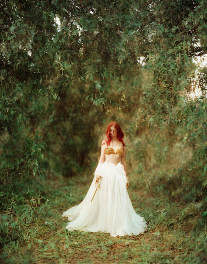 Red-haired woman in white dress surrounded by greenery