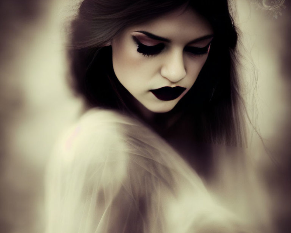 Portrait of a person with black lipstick and dramatic eye makeup veiled in white.