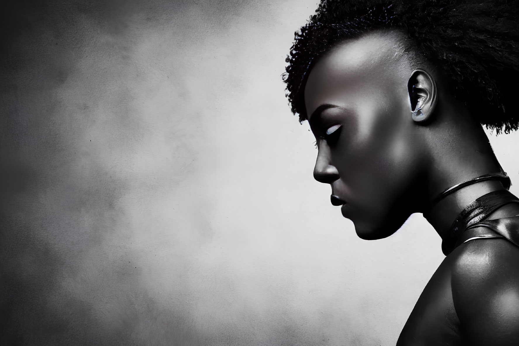 Portrait of Woman with Dark Skin and Short Curly Hair in Metallic Choker on Textured Gray Background