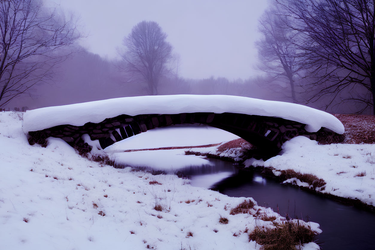 Snow-covered Stone Footbridge Over Tranquil Stream in Winter Landscape