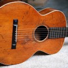 Glittery orange galaxy-themed acoustic guitar on monochrome backdrop