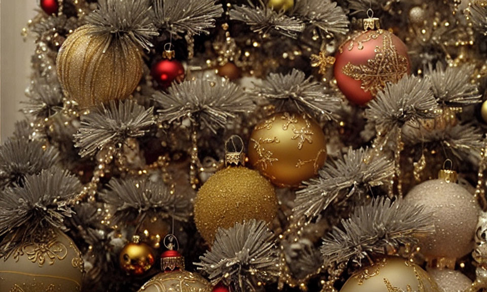 Decorated Christmas tree with gold and red baubles and silver tinsel