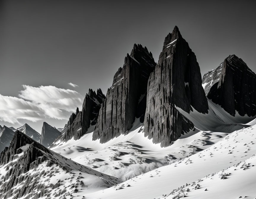 Snow-covered jagged mountain peaks in dramatic black and white tones