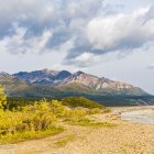 Scenic landscape: golden hills, winding river, snow-capped mountains