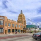 Vintage street scene with art deco architecture and classic cars under streaked clouds