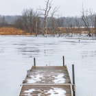 Serene monochrome frozen lake with dock and misty background