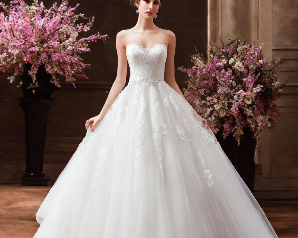 Elegant woman in white lace wedding gown with floral backdrop