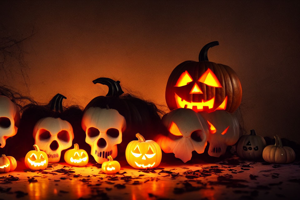 Assorted Halloween decorations: carved pumpkins, skull lanterns, cobwebs, autumn leaves on dark