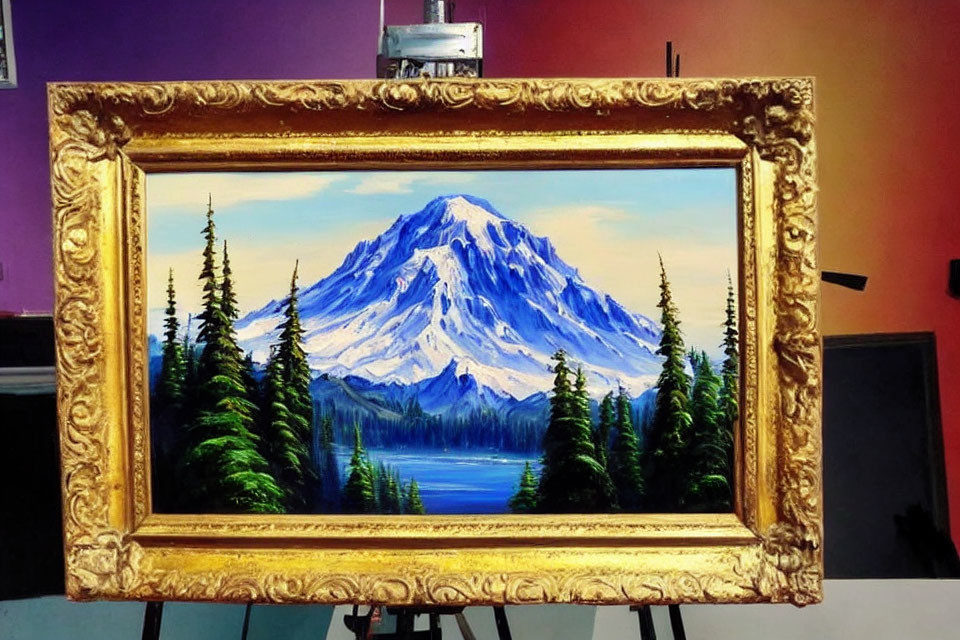 Snow-capped mountain painting in gold frame on easel