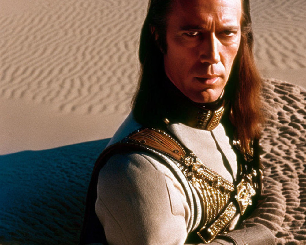 Man in Long Hair in Military-Style Uniform Kneeling in Desert