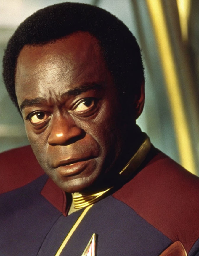 Man in red and black Starfleet uniform with concerned expression