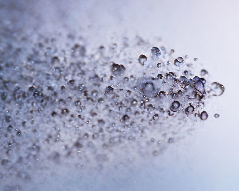 Water droplets suspended on gradient blue to white background.