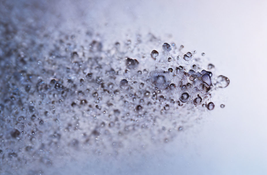 Water droplets suspended on gradient blue to white background.