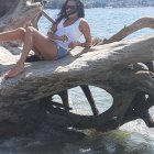 Mermaid with long hair beside large fish on rock in serene marine scene