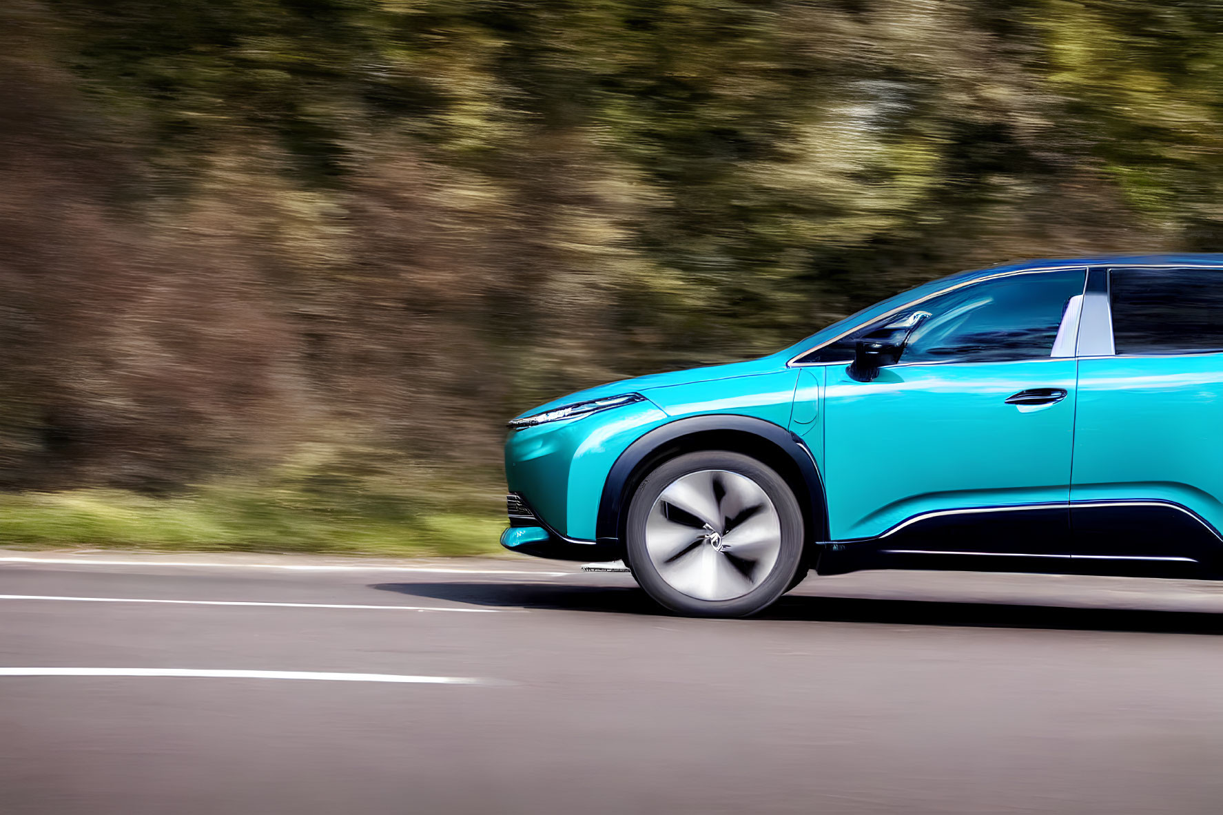 Teal Electric SUV Speeding on Asphalt Road