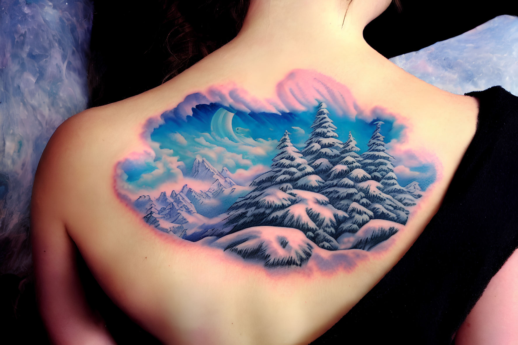 Colorful back tattoo of heart-shaped mountain landscape with pine trees and sky.