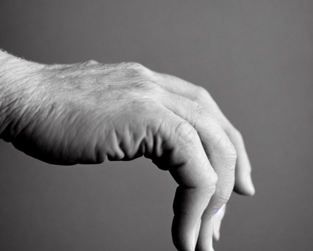 Monochrome close-up of human hand with curled fingers