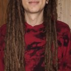 Regal man with long hair in crown and ornate red robes