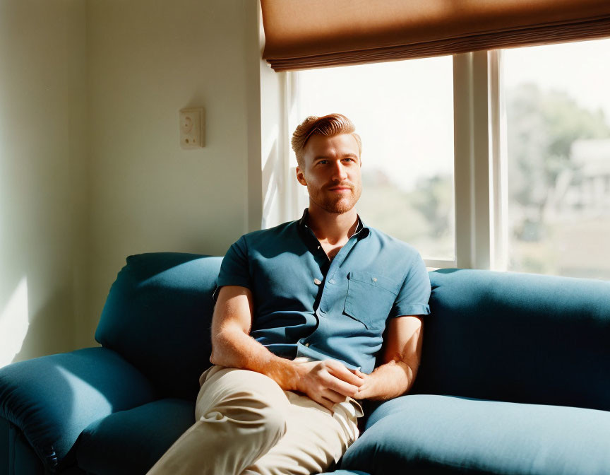 Man with Combed Hair Relaxing on Blue Couch with White Mug