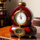 Red and Gold Mantel Clock with Roman Numerals on Polished Wood Surface