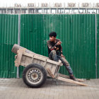 Masked figure in red cloak on futuristic motorcycle in bamboo setting