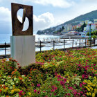 Seaside Painting with Blooming Flowers, Statue, and Hills