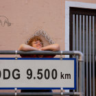 Mural featuring woman by construction barrier with "DDG 9.600 km" sign