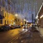 Night scene with people on cobblestone street under crescent moon